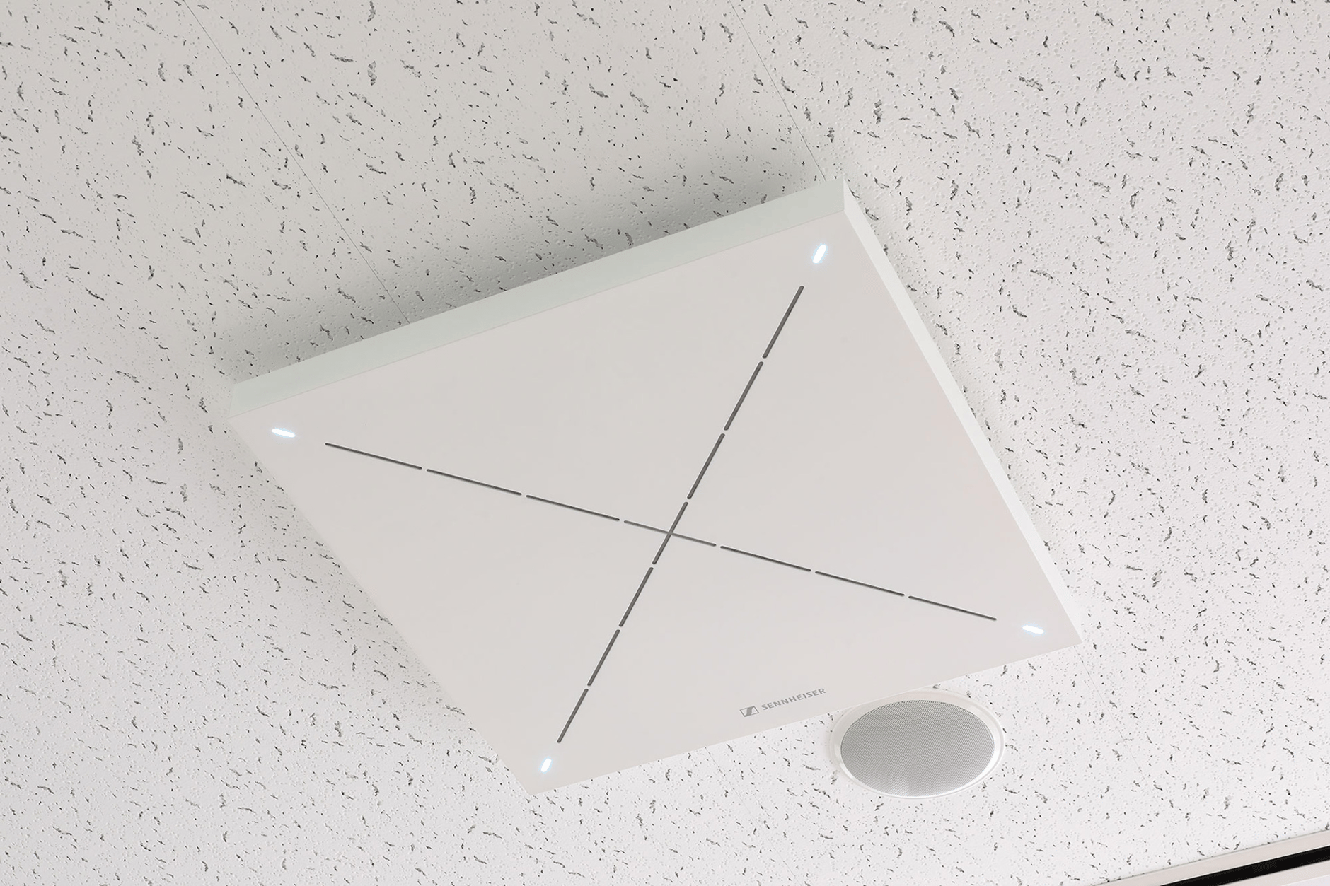 Sennheiser ceiling microphone with LED indicators installed on a white textured ceiling.