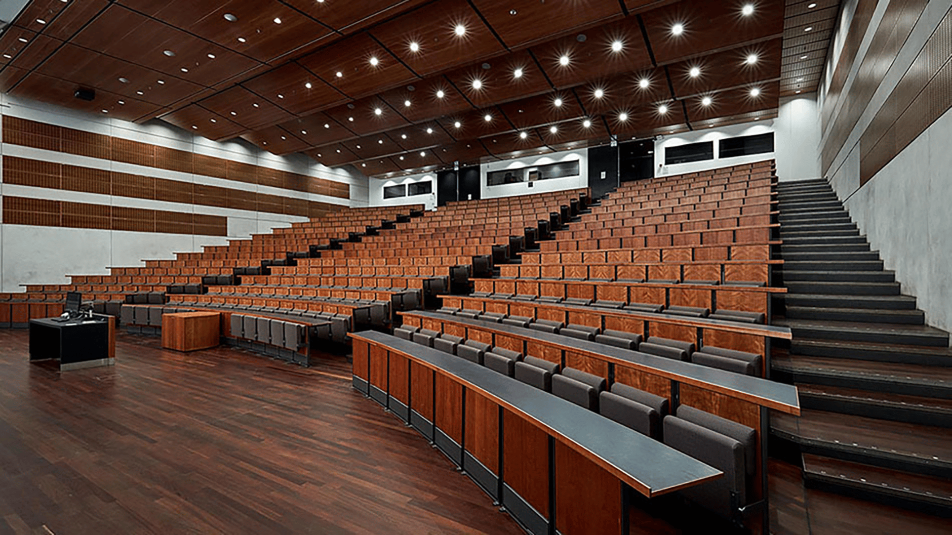 Lecture hall at Copenhagen Business School with wooden seating and modern lighting.