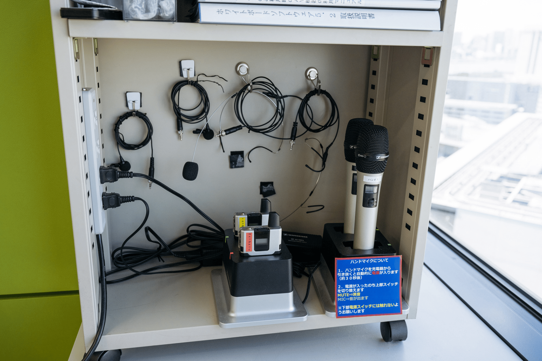 Sennheiser handheld microphone and bodypack transmitters in a charging bay.
