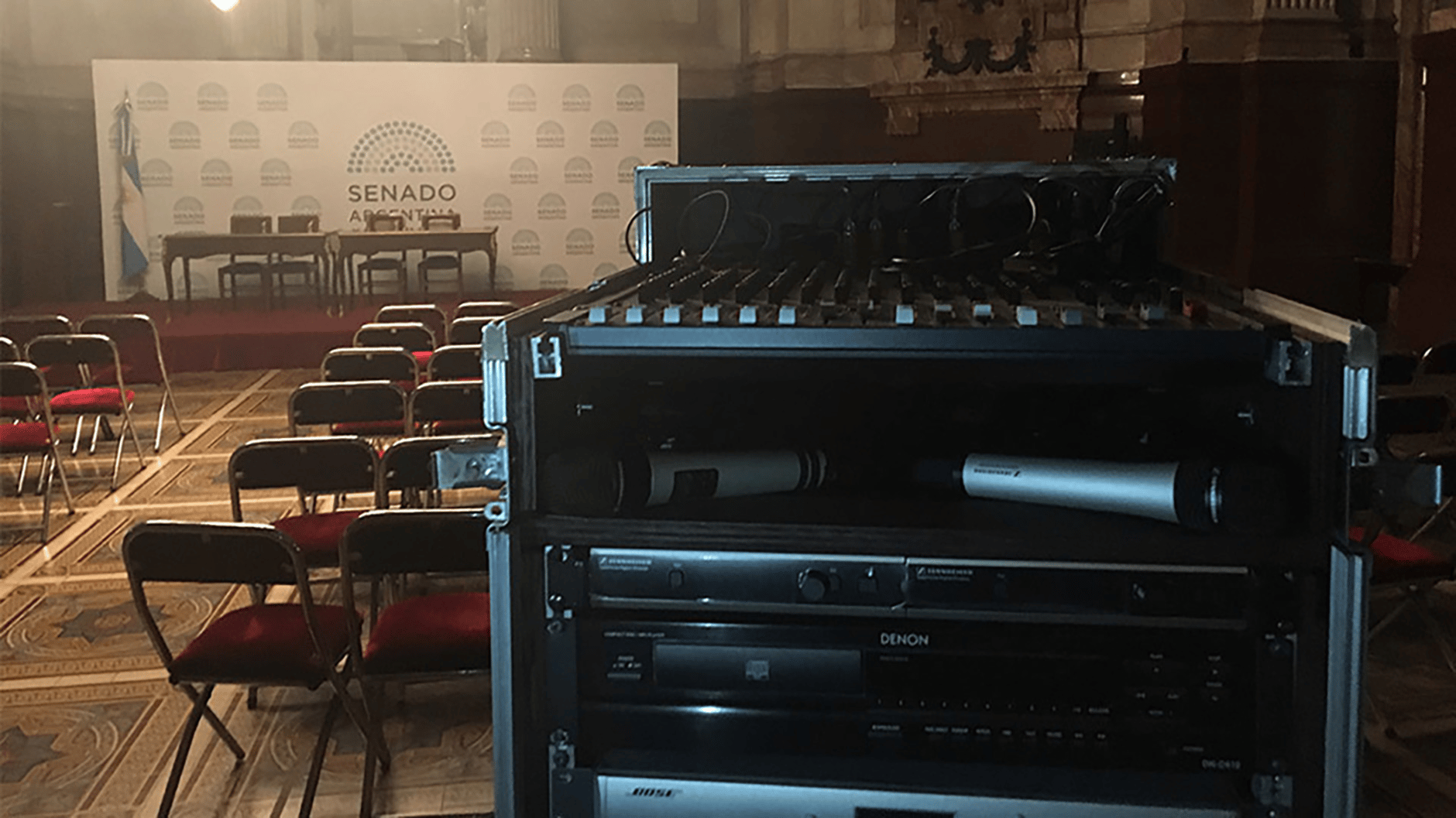 Audio equipment rack system in the National Senate of Argentina with empty chairs and a podium in the background.