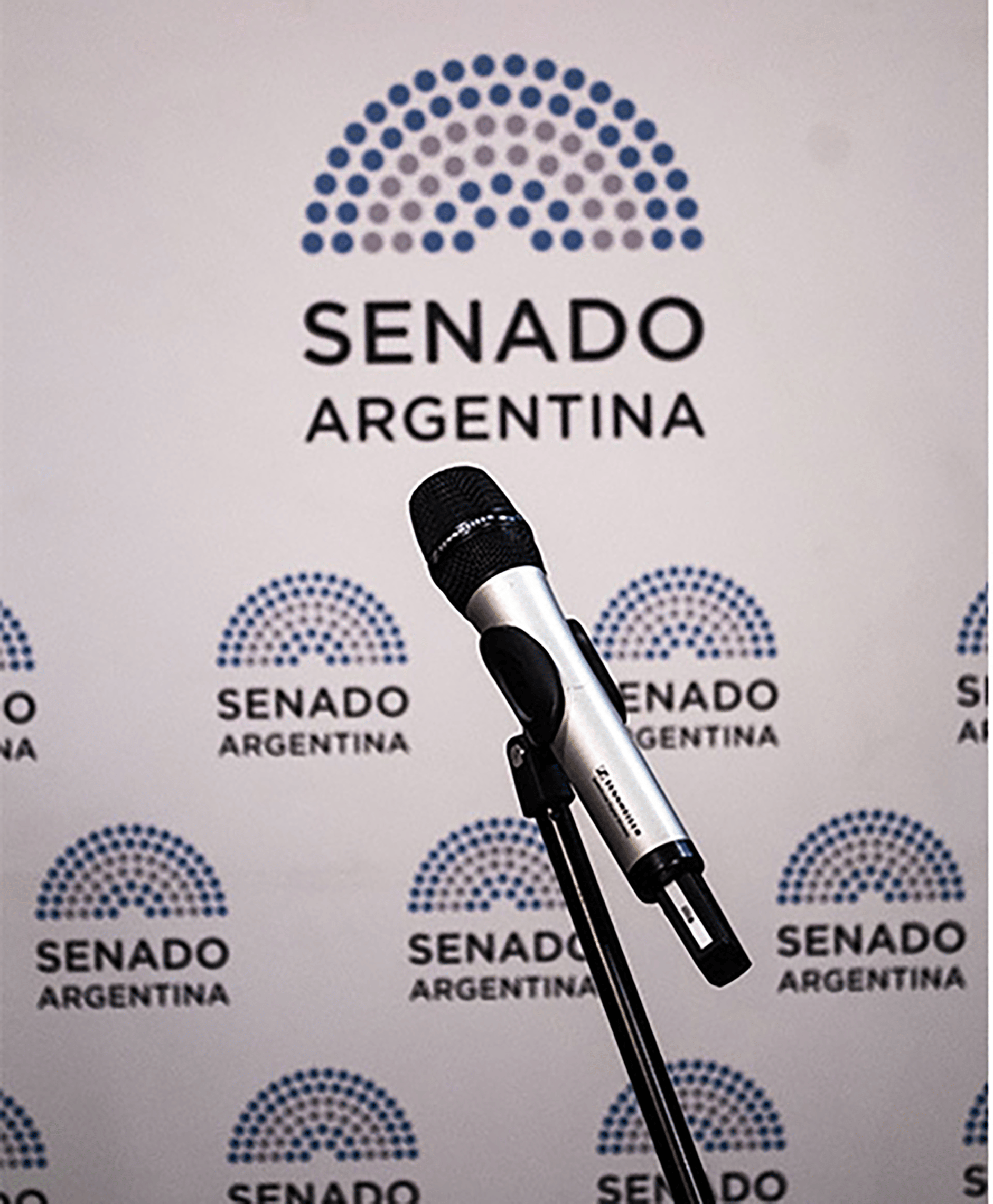 Microphone on stand in front of Senado Argentina logo wall