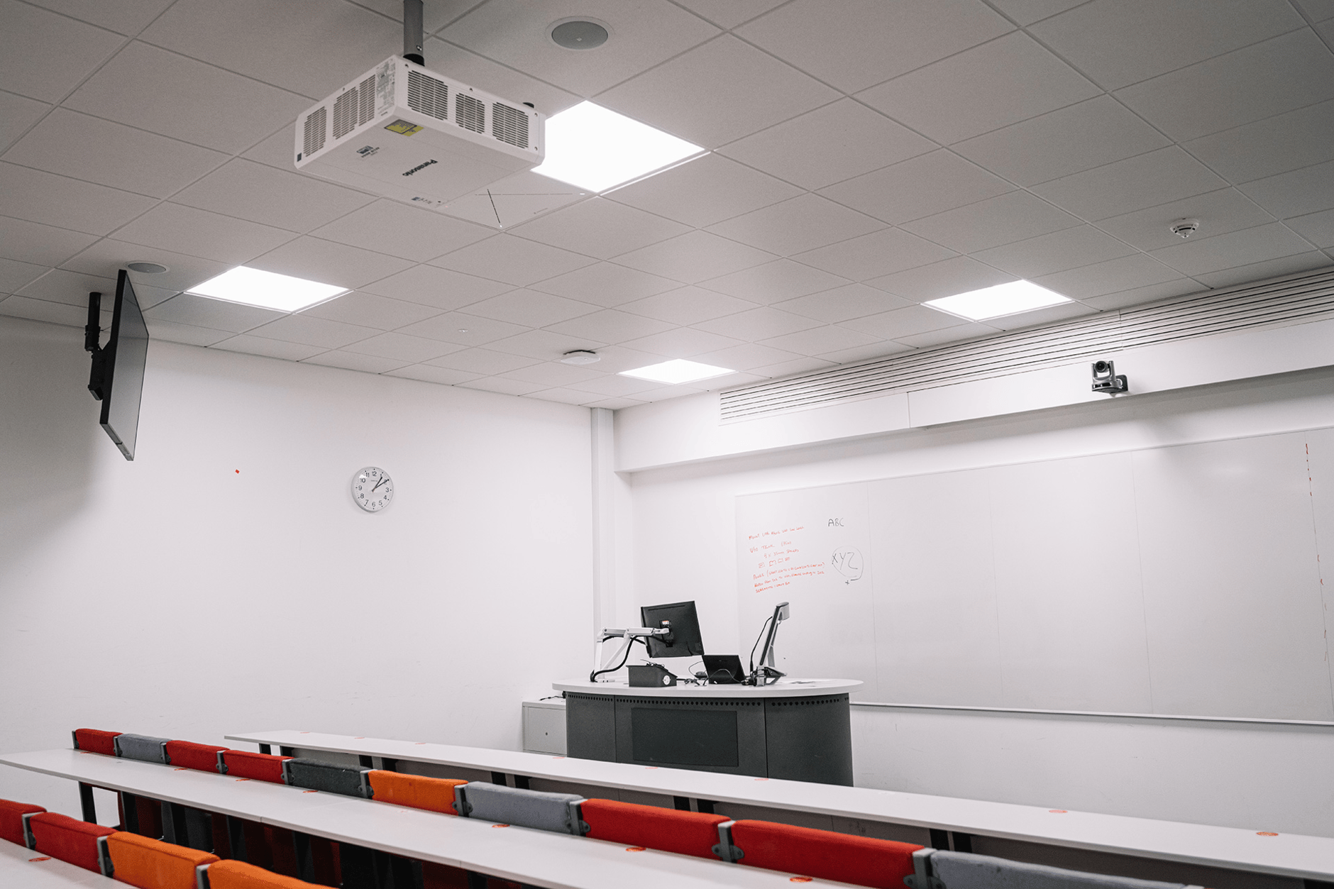 Lecture room at Queen's University Belfast with desks, projector, and whiteboard.