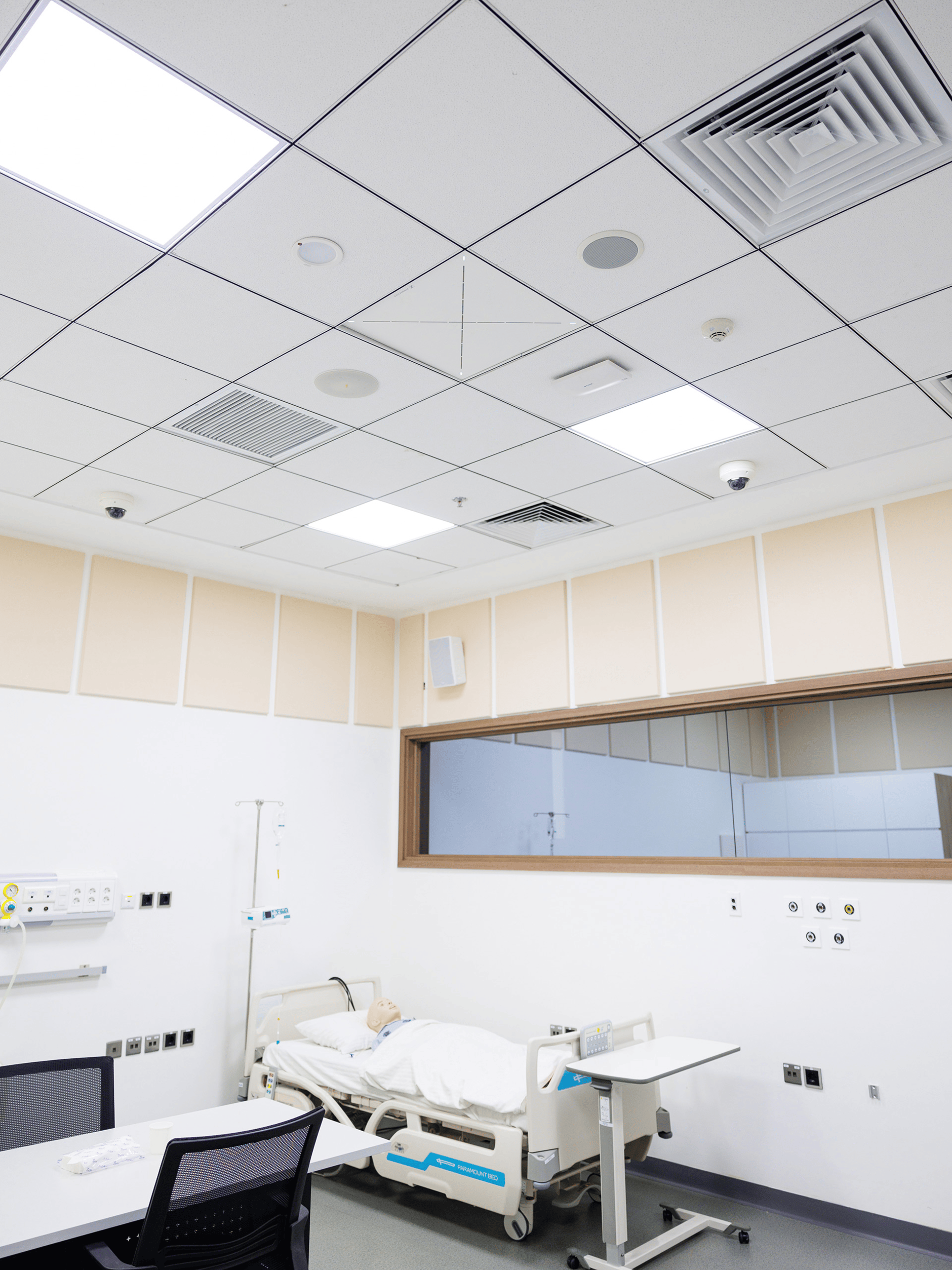 Modern medical room with hospital bed and advanced ceiling-mounted equipment.