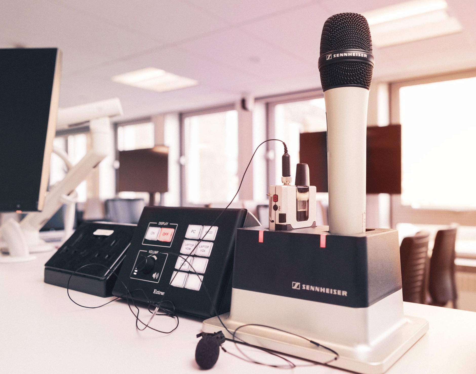 Sennheiser wireless microphone system on a desk in a modern office setting.