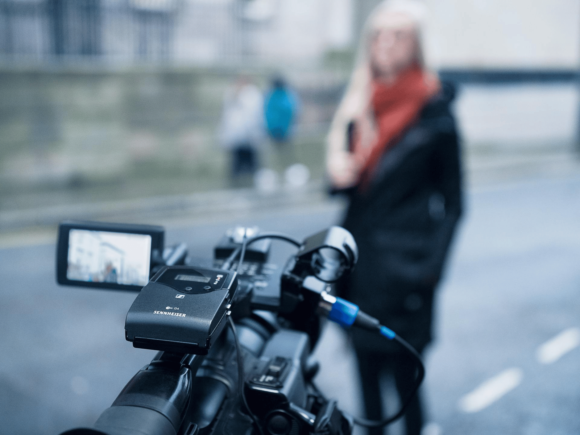 Sennheiser wireless microphone system attached to a video camera during an outdoor interview.