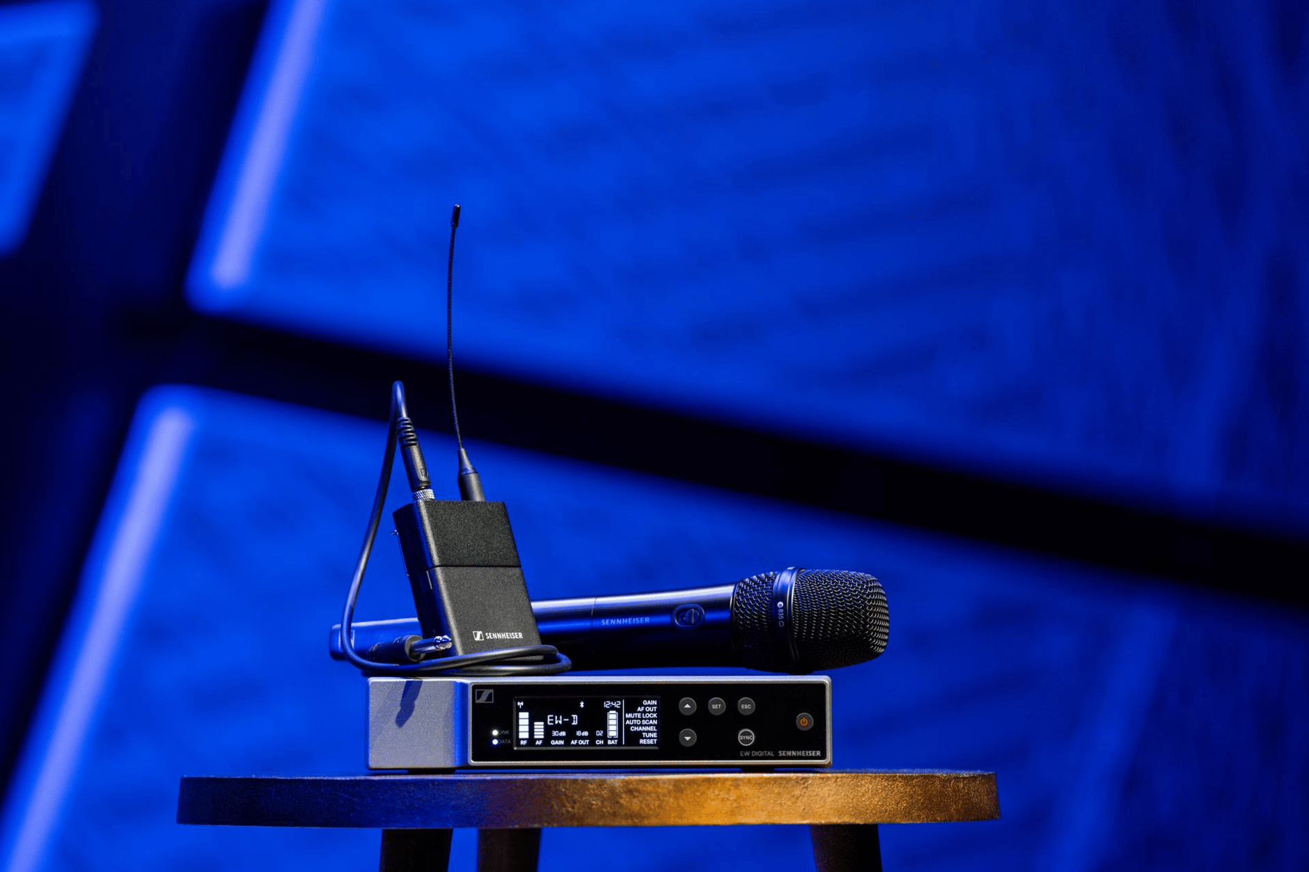 Sennheiser wireless microphone system with receiver and transmitter on a table.