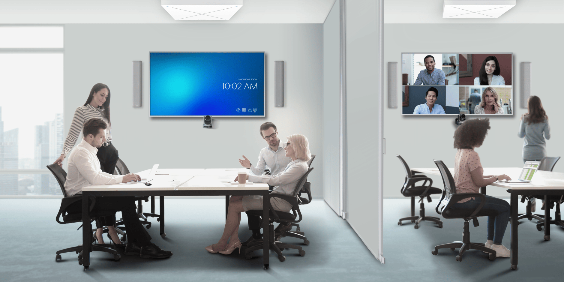 Office meeting room with video conferencing setup and people collaborating.