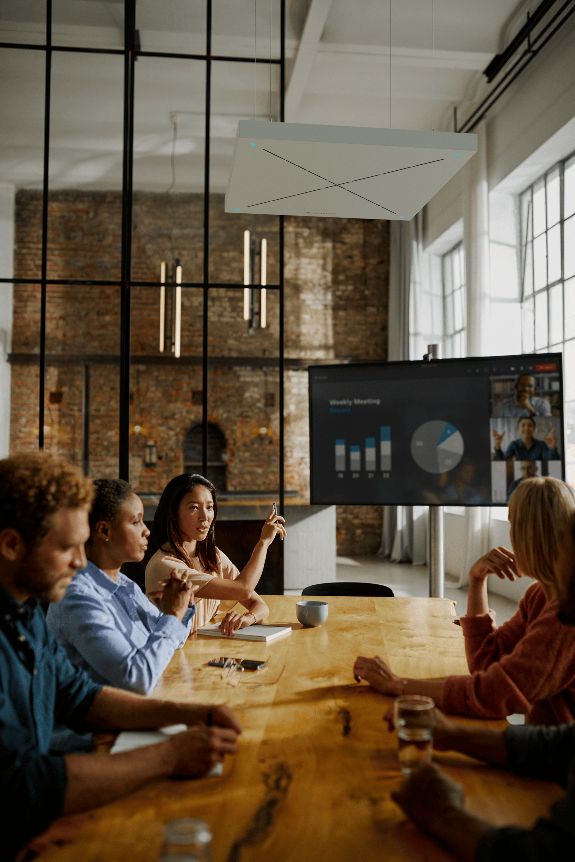 People in a modern conference room having a meeting with a presentation on a screen.
