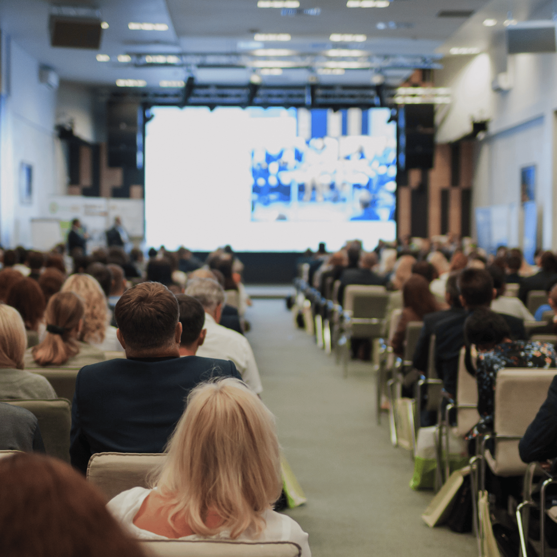 Audience attending a conference in a modern auditorium.