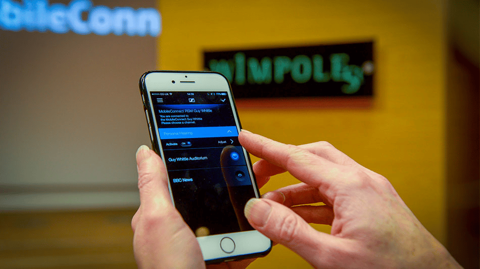 Person using a smartphone app in a conference room.