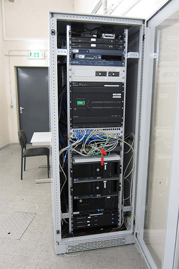 Server rack with networking equipment and cables in a university data center.