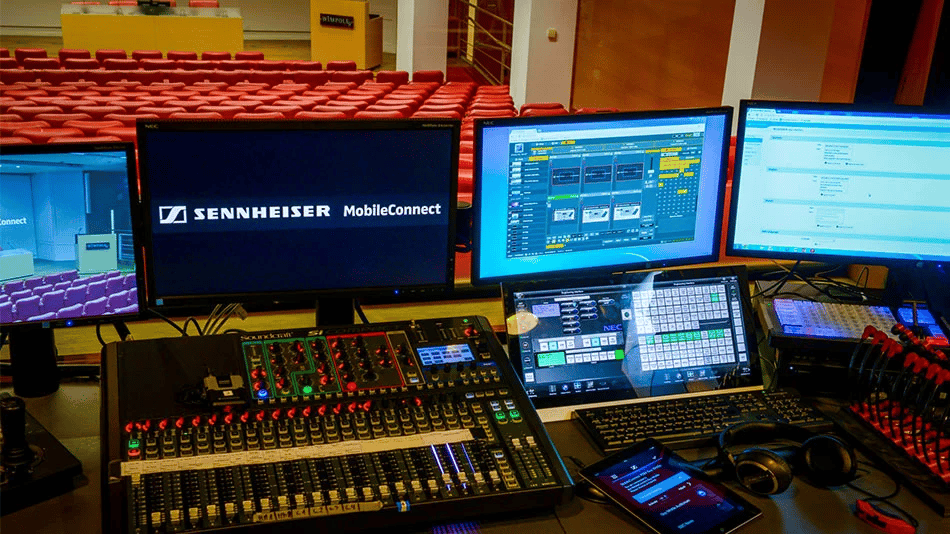 Audio control room with Sennheiser MobileConnect setup in a conference hall.