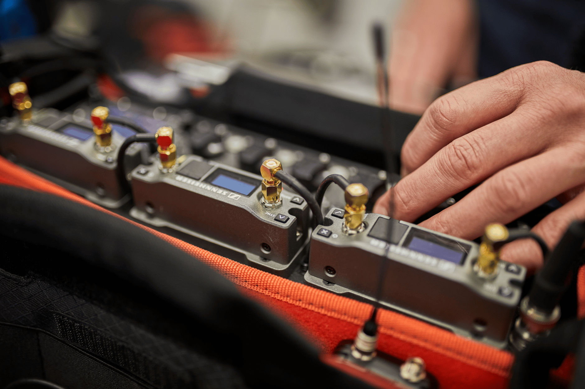 Person adjusting Sennheiser EK 6042 wireless receivers in a professional audio setup.