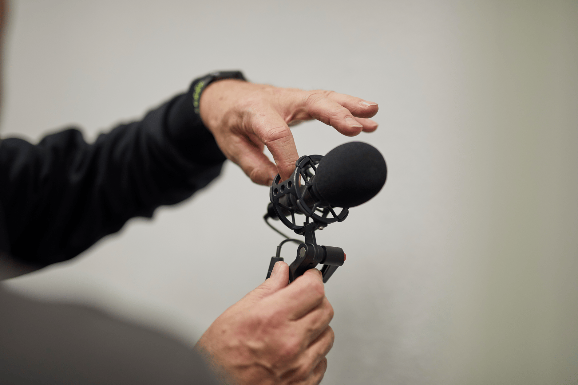 Person adjusting Sennheiser MKH 8050 microphone in shock mount