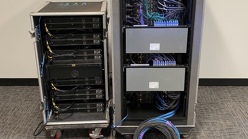 Audio equipment rack with cables and network connections in a server room.