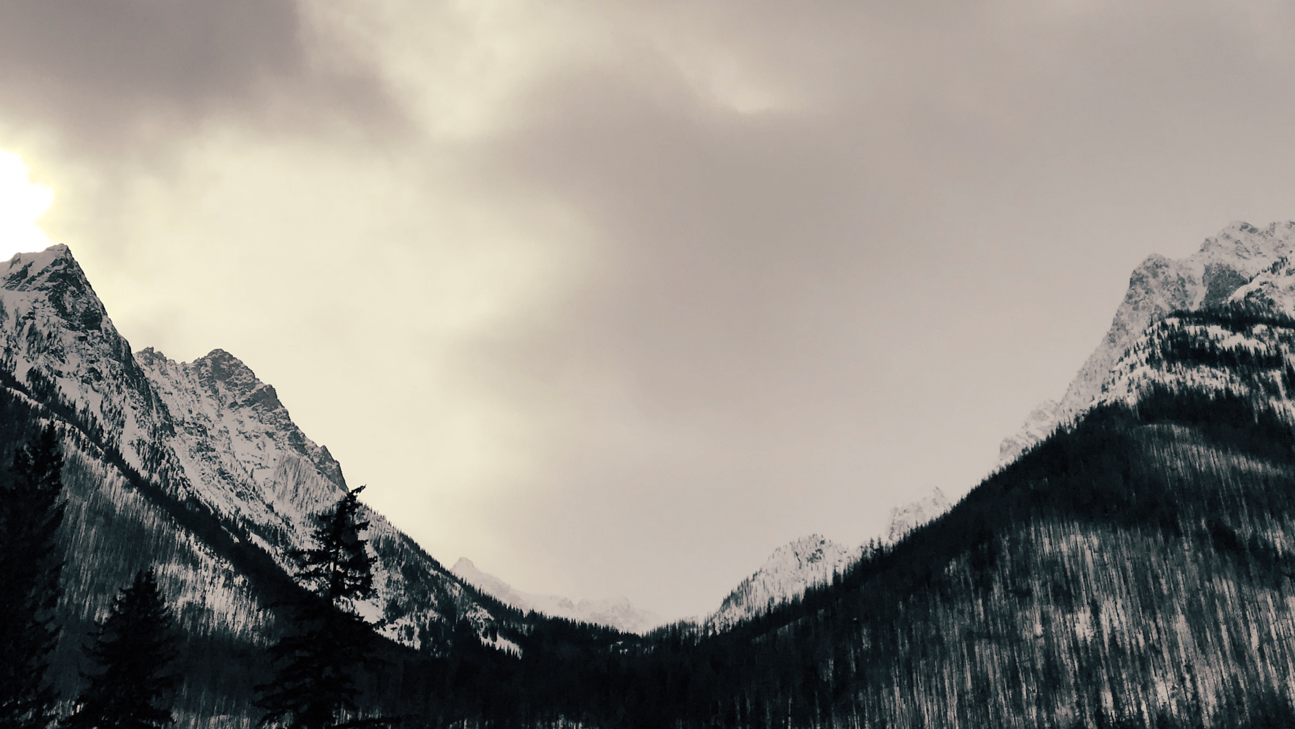 Snow-covered mountain range under a cloudy sky in the Eastern Cascades.