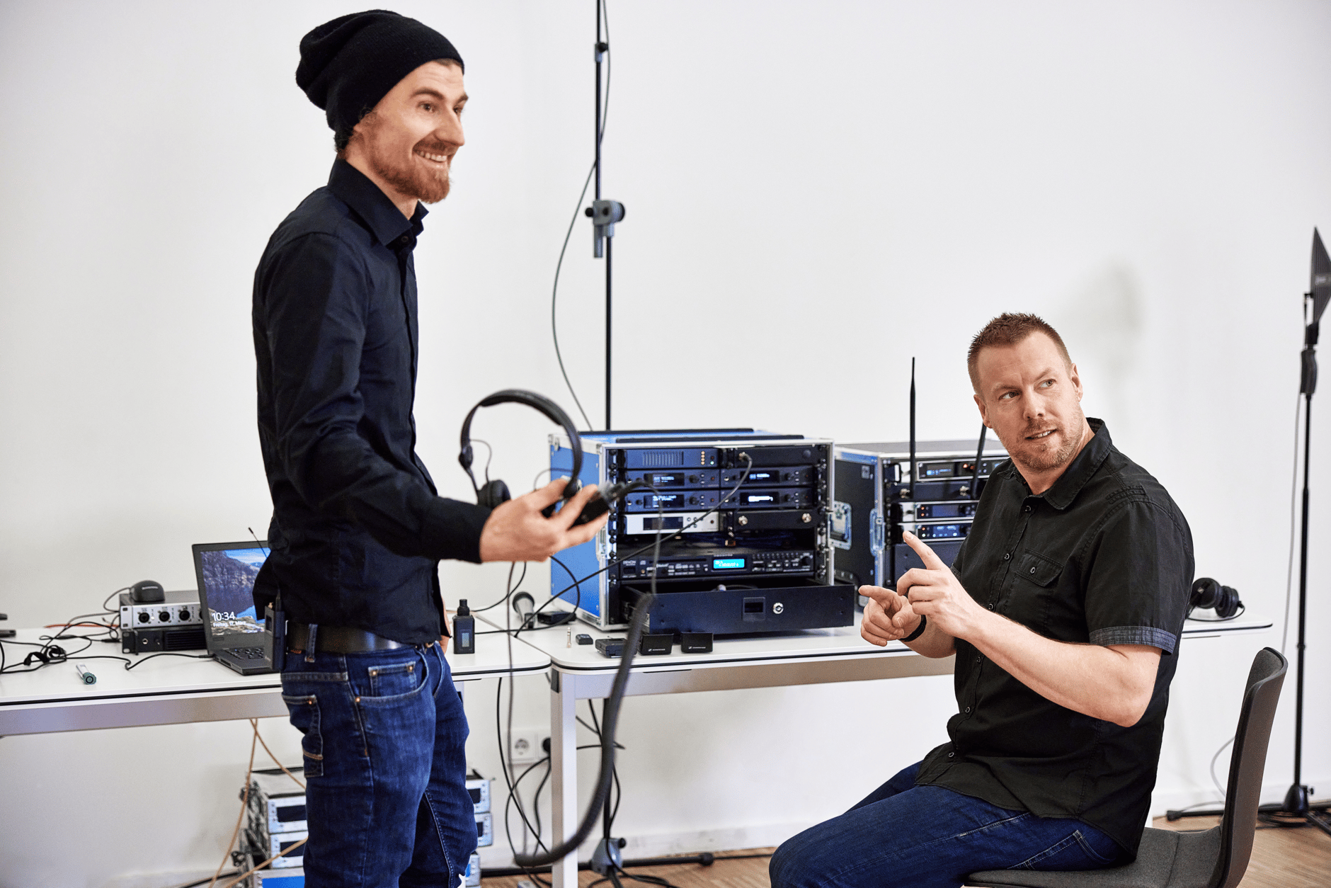 Two men setting up audio equipment in a studio.