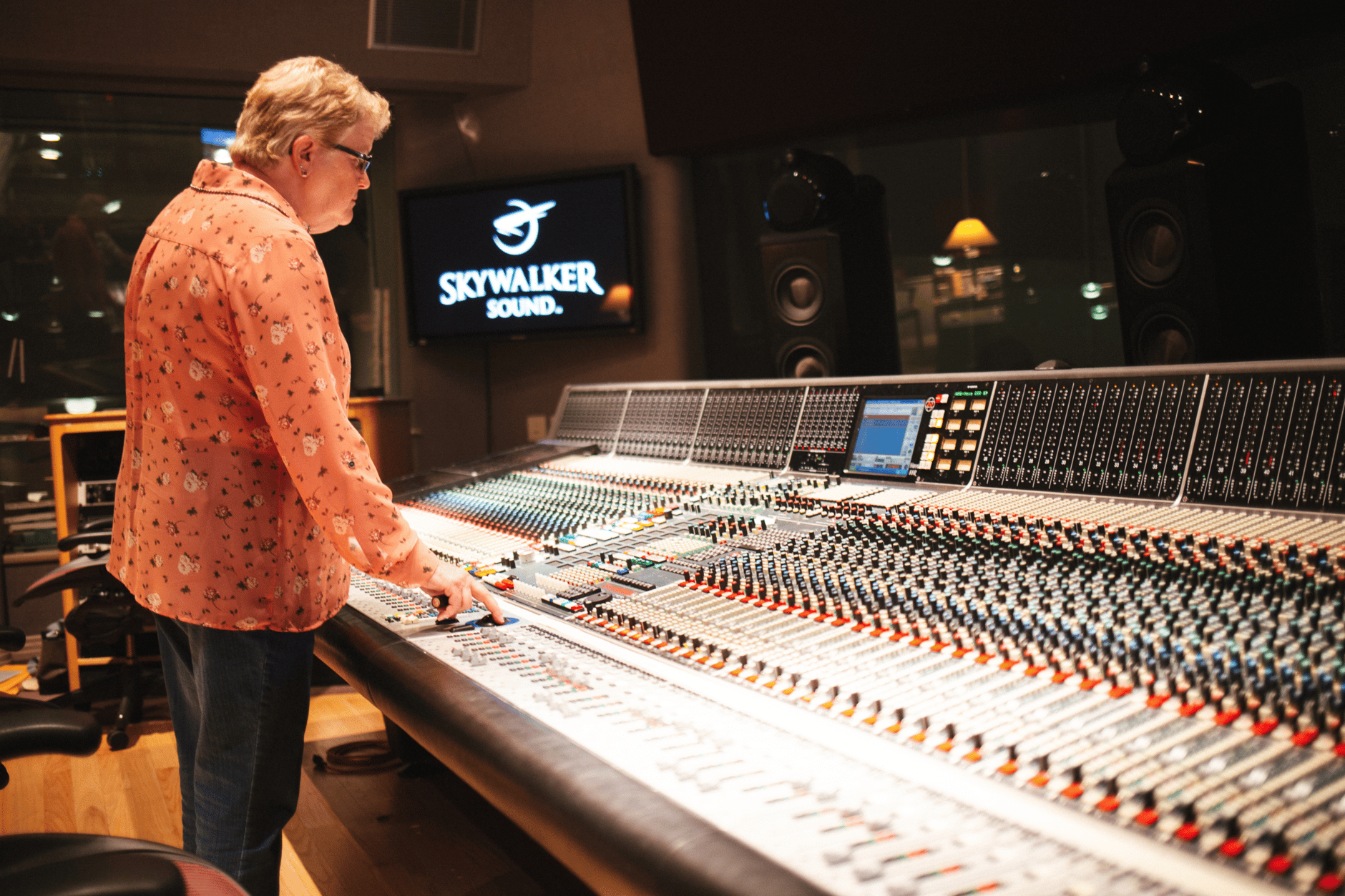 Person operating a large audio mixing console at Skywalker Sound studio.