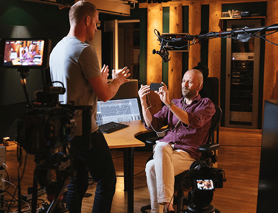 Two men discussing audio equipment in a professional recording studio.