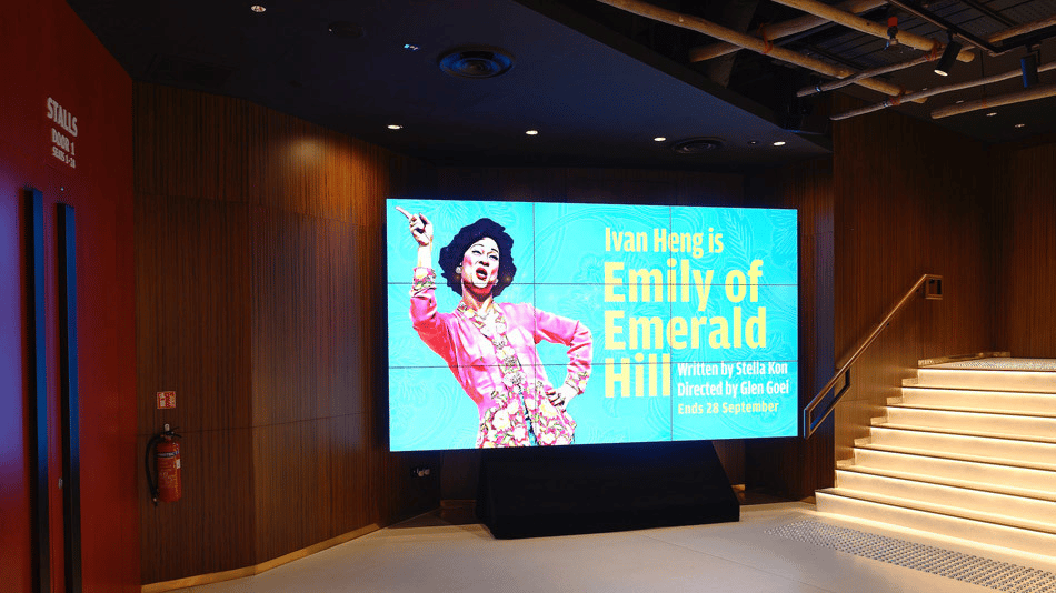 Ngee Ann Kongsi Theatre foyer with large screen displaying "Emily of Emerald Hill" by Ivan Heng.