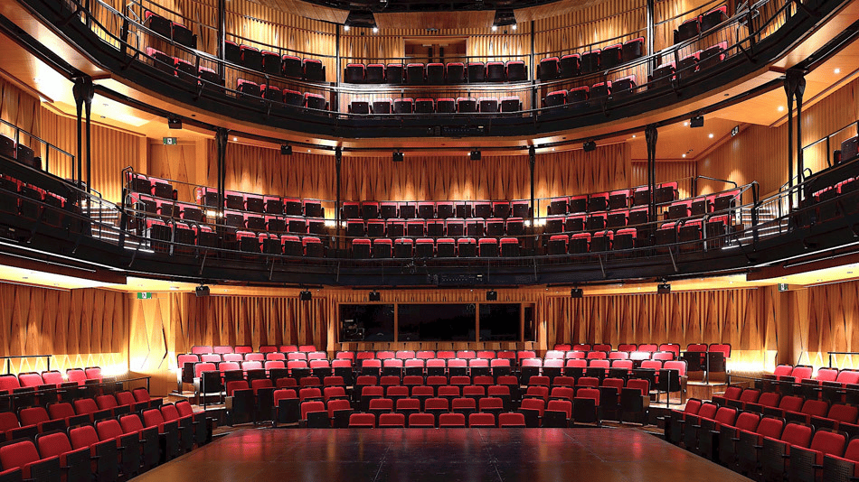 View of Ngee Ann Kongsi Theatre from the stage with red and black seating and wooden interior.