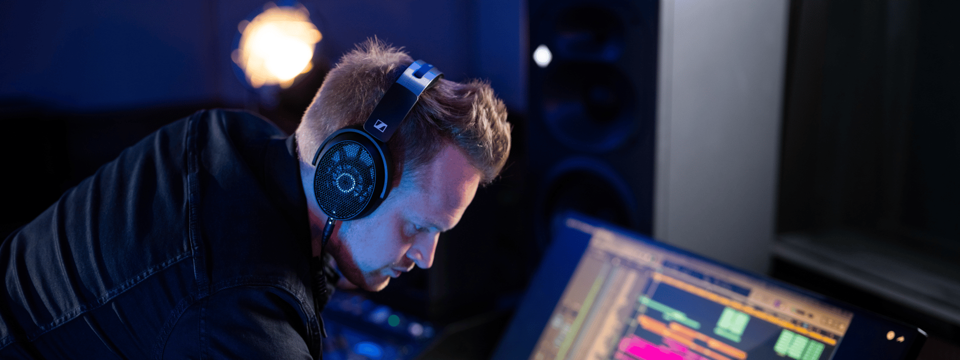 Man wearing Sennheiser HD 490 Pro headphones working on audio production.