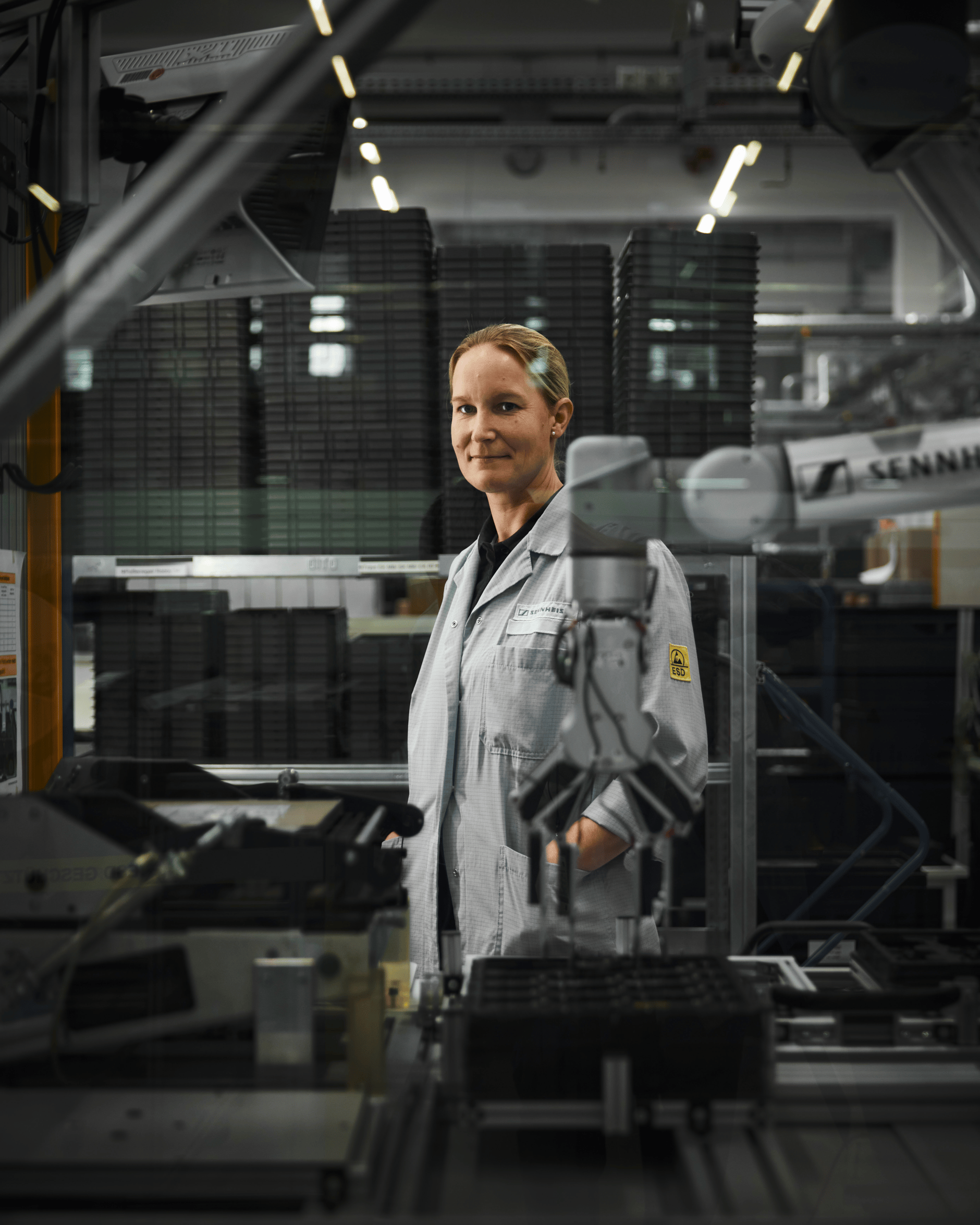 Woman in lab coat working in a high-tech manufacturing facility.