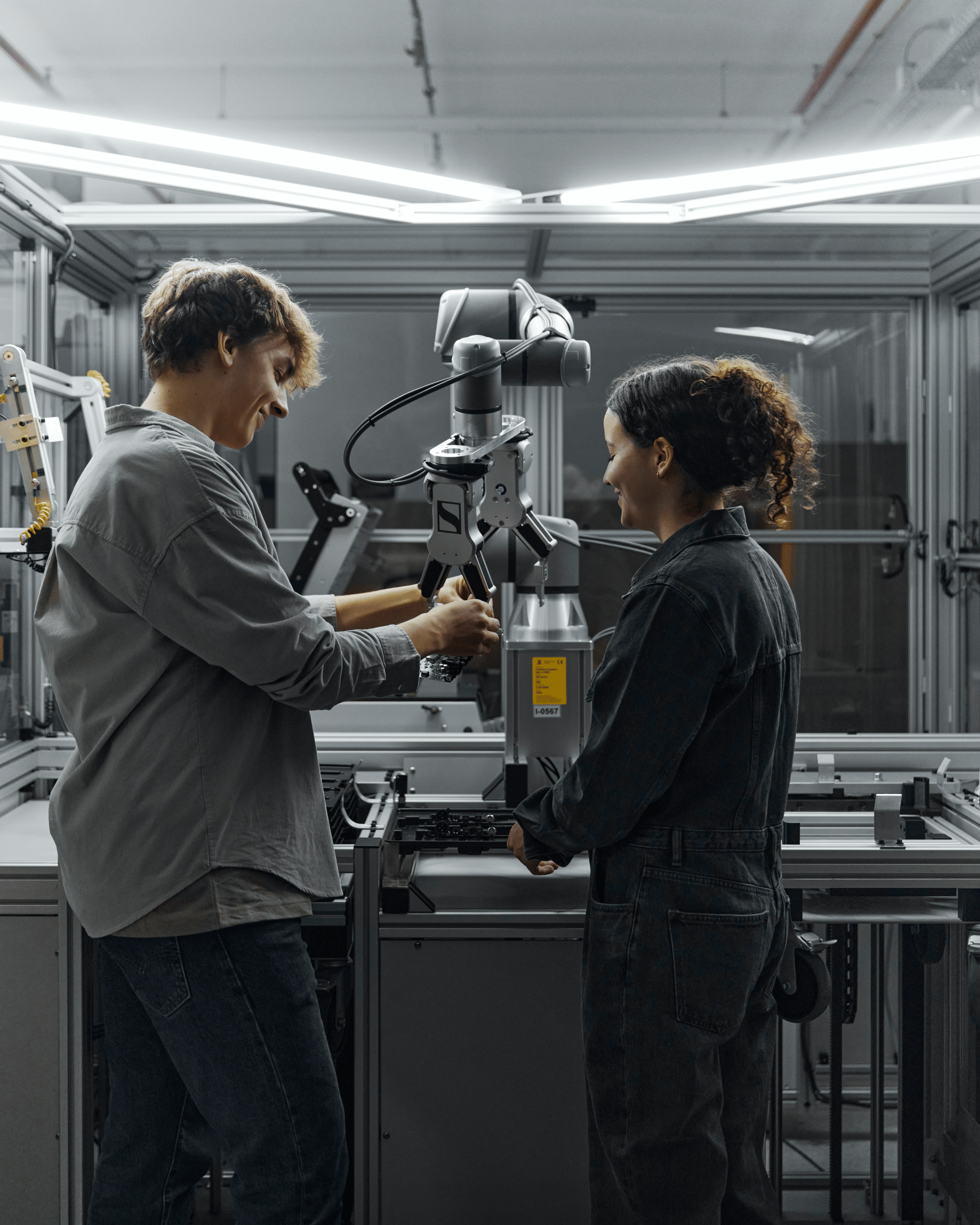 Two people working with advanced machinery in a Sennheiser production facility.