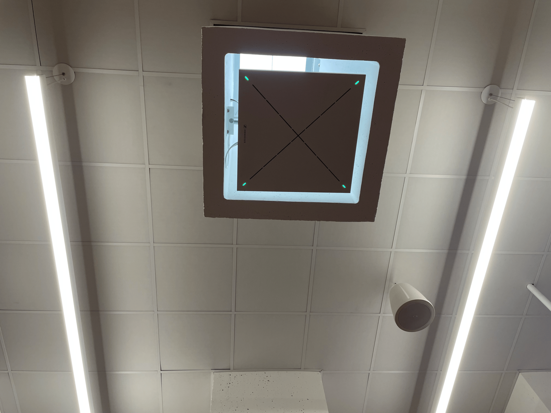 Ceiling-mounted Sennheiser TeamConnect Ceiling 2 microphone in a modern office setting.
