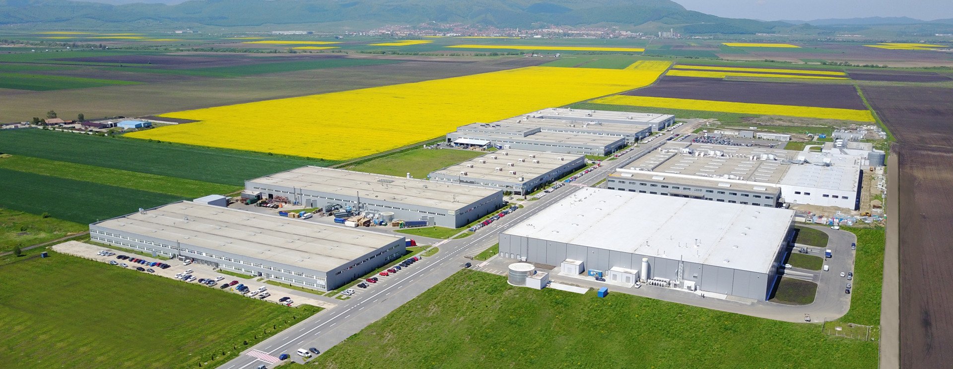 Aerial view of Sennheiser production site in Brasov, Romania surrounded by fields and nature.