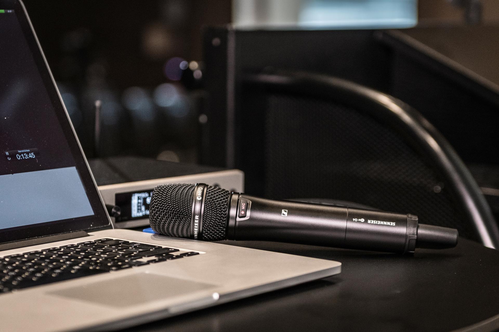 Sennheiser G4 wireless microphone next to a laptop on a desk.