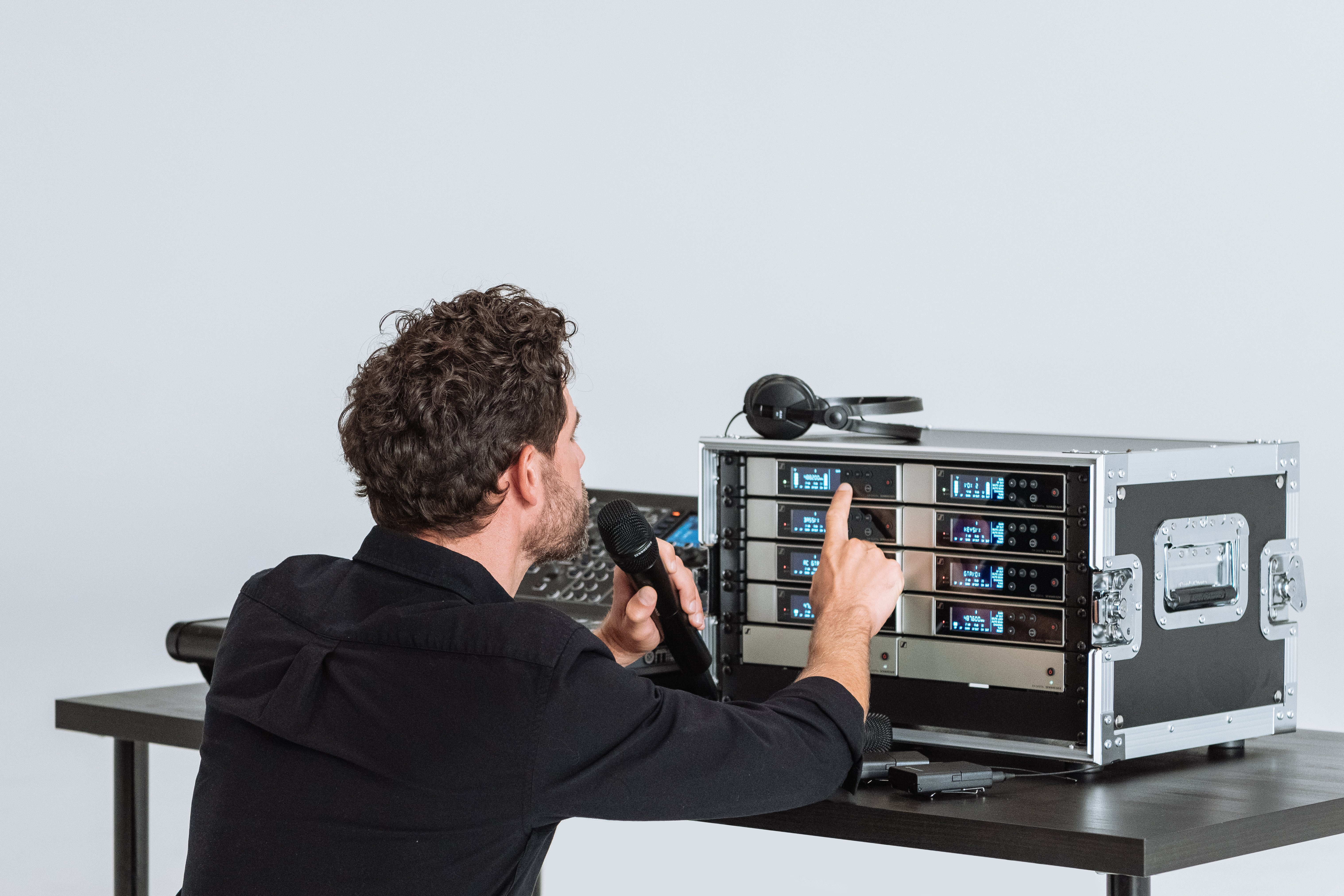 Man adjusting Sennheiser Evolution Wireless Digital audio equipment.
