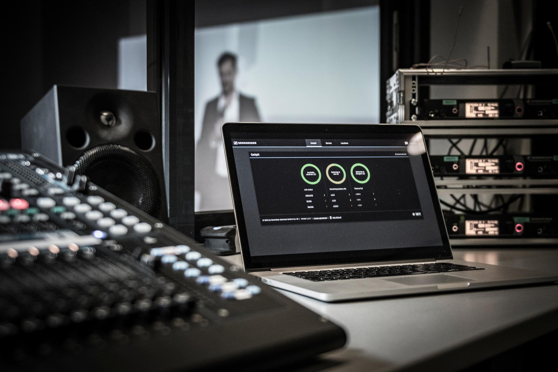 Laptop displaying monitoring control software in a professional audio setup.