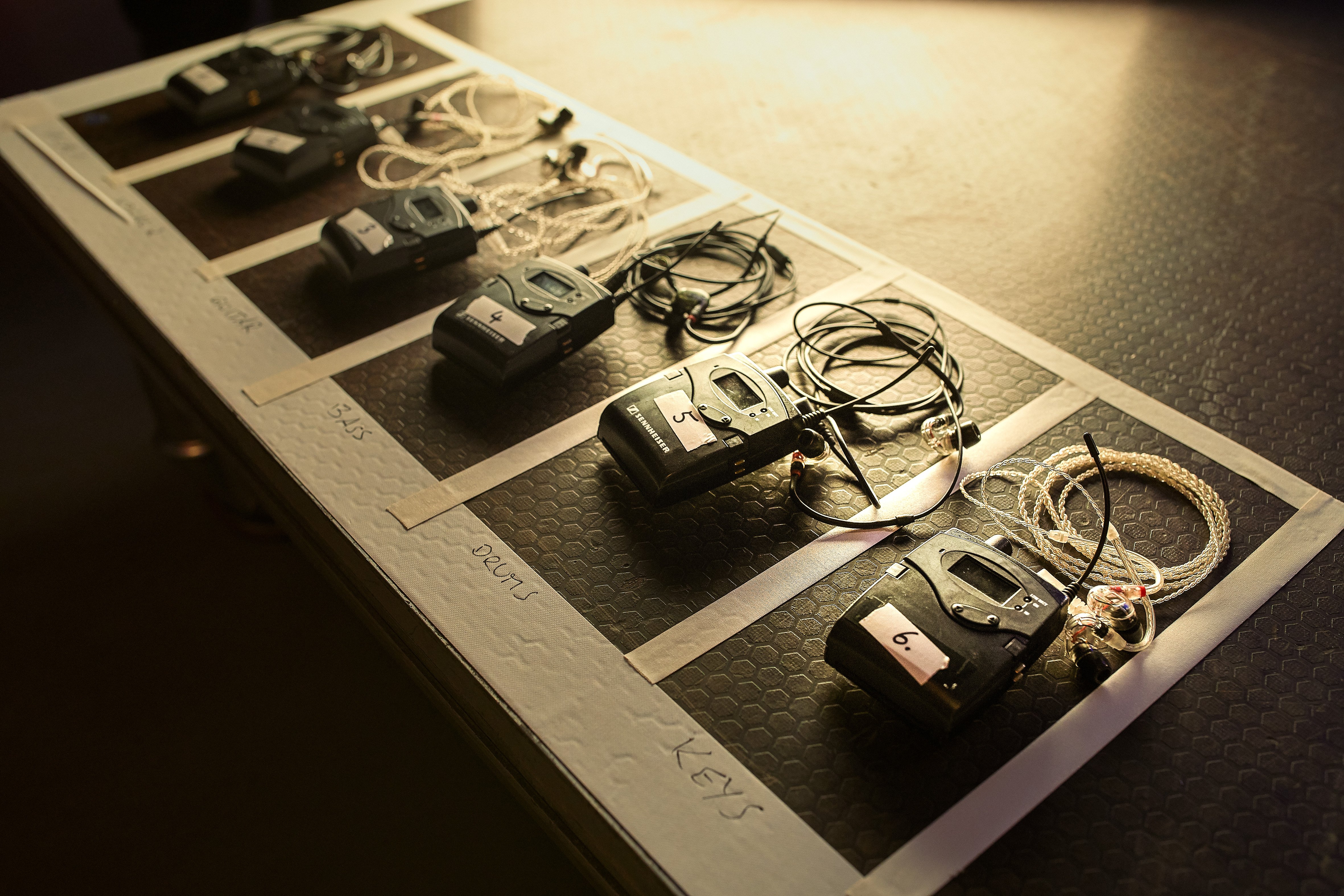 Wireless microphone transmitters and receivers organized on a table.