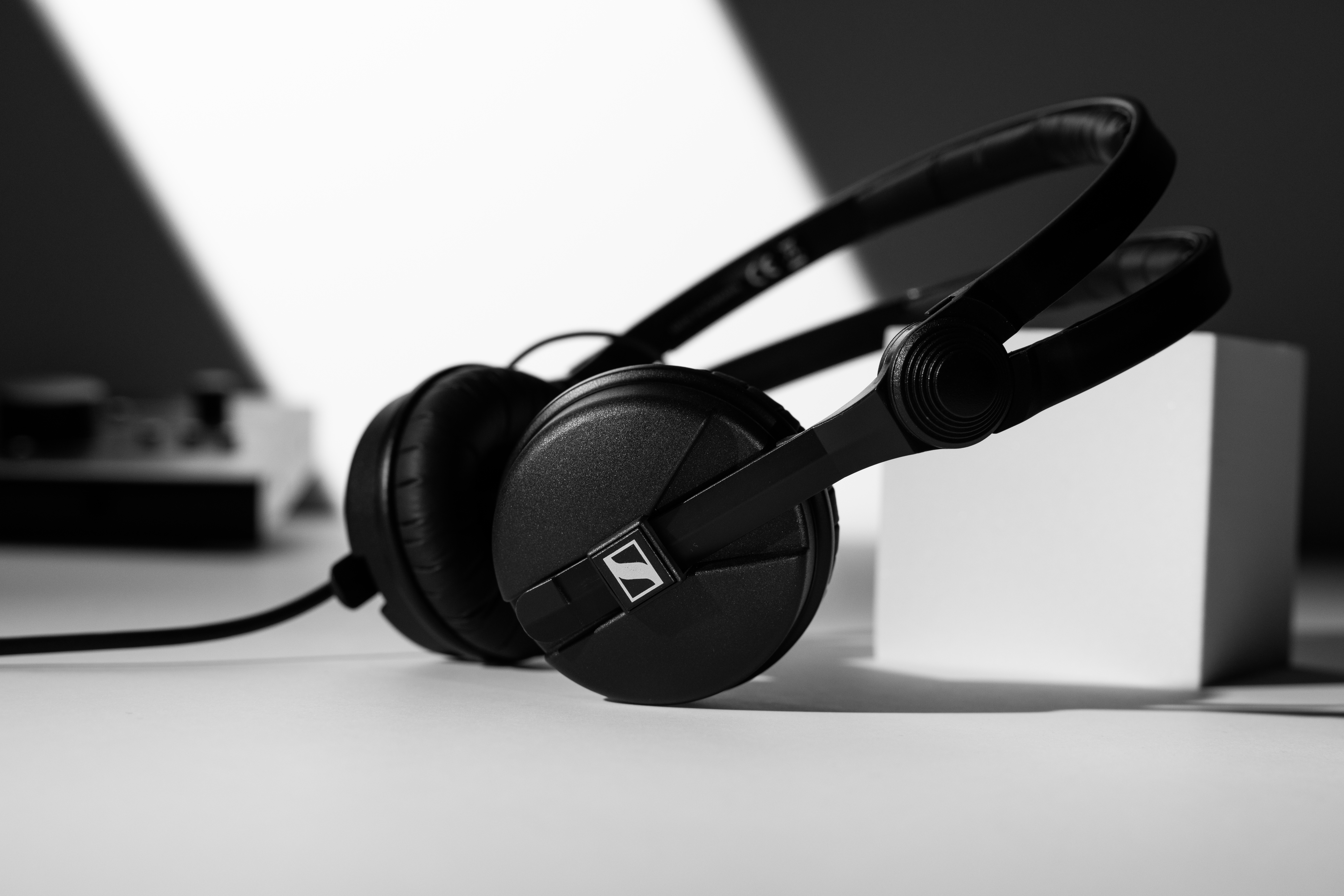 Sennheiser HD 25 headphones in black on a white surface.