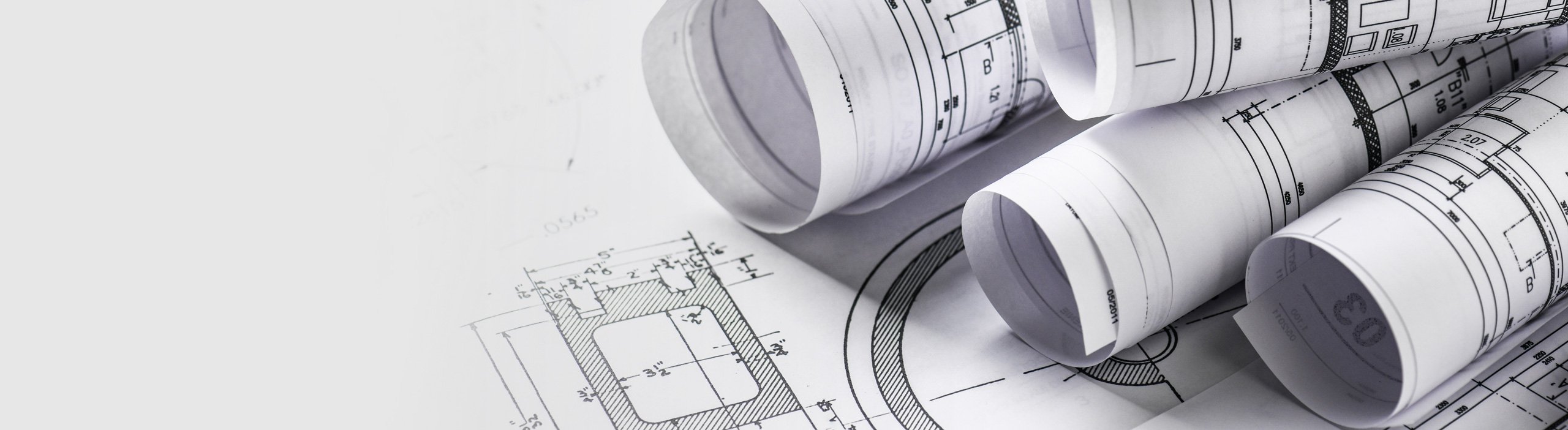 Rolled architectural blueprints on a technical drawing background.