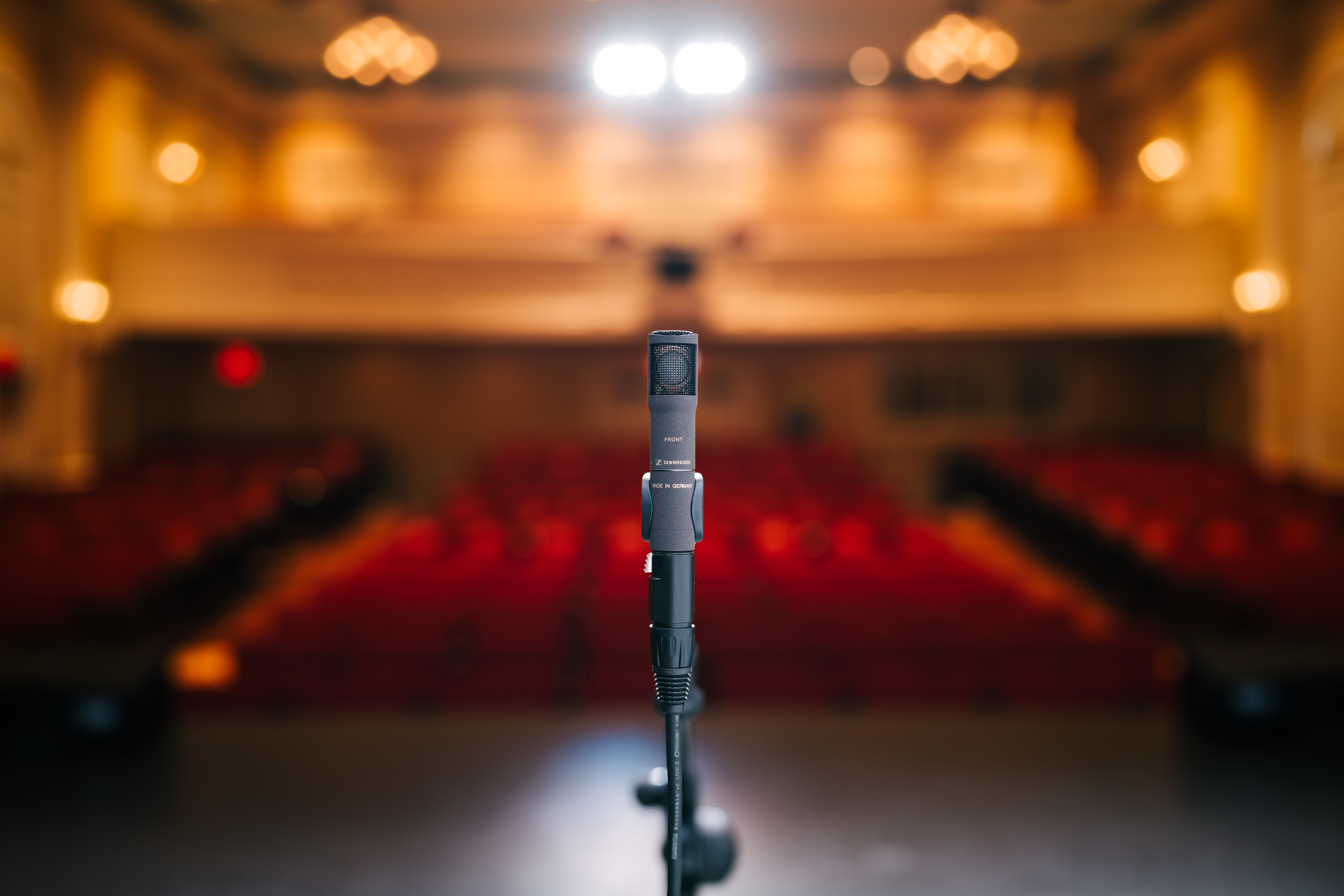 Sennheiser MKH 8030 microphone on stage with blurred auditorium background